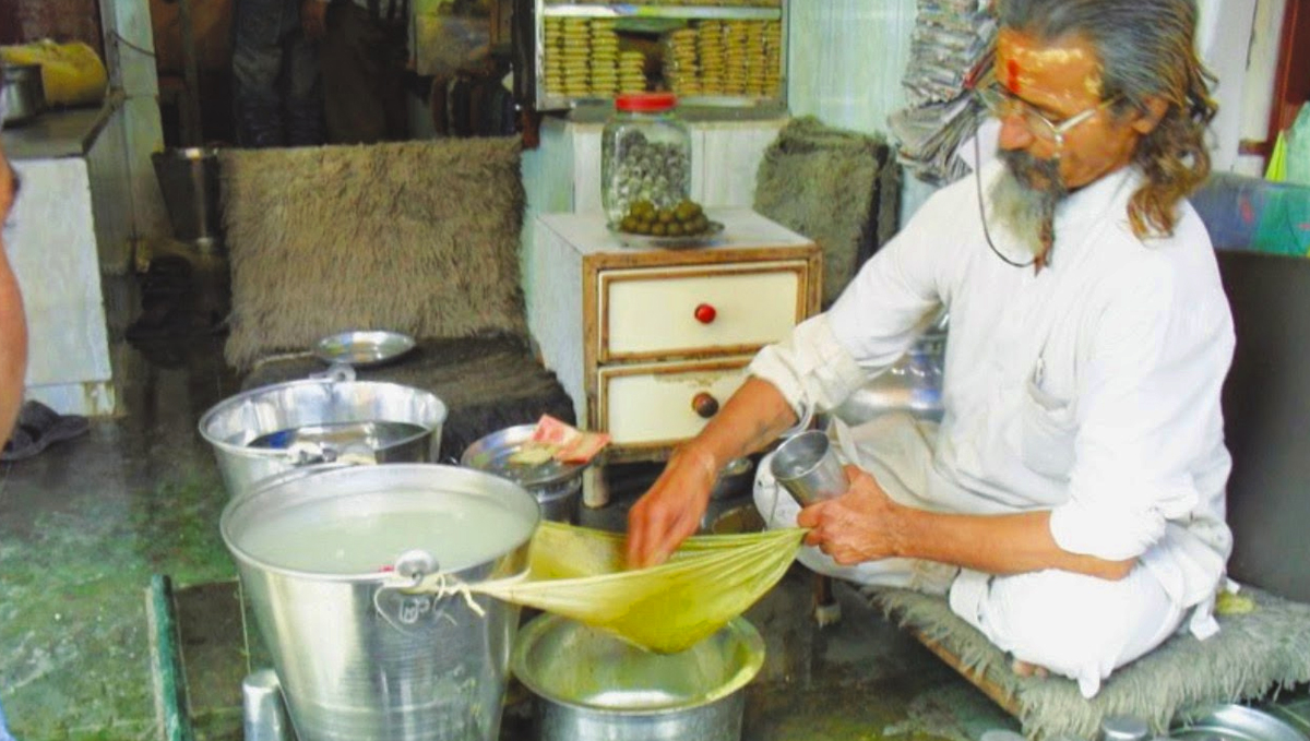 Indian man making cannabis bhang.