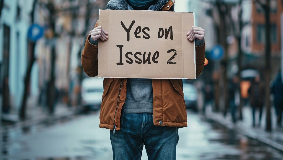 Weed in Ohio: Cannabis Legal Status Guide: A man in the street holding a Yes on Issue 2 sign Weed in Ohio: Cannabis Legal Status Guide: A man in the street holding a Yes on Issue 2 sign