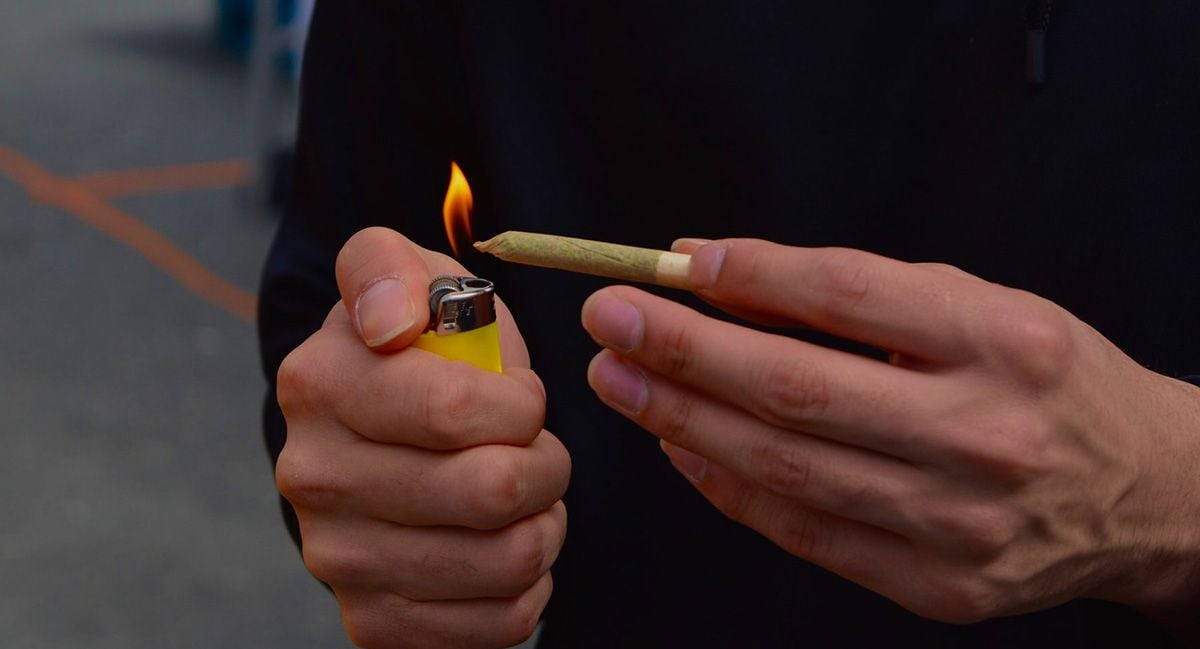 A young man's hands as he's lighting up a joint