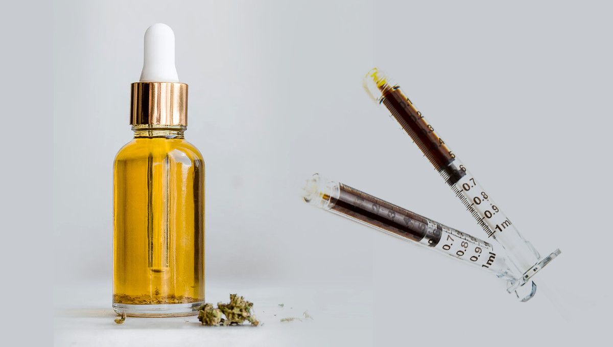 What is Rick Simpson Oil (RSO): Does It Work? A bottle of golden-colored oil, a pinch of cannabis lying next to it, and two syringes with a darker-colored substance in them