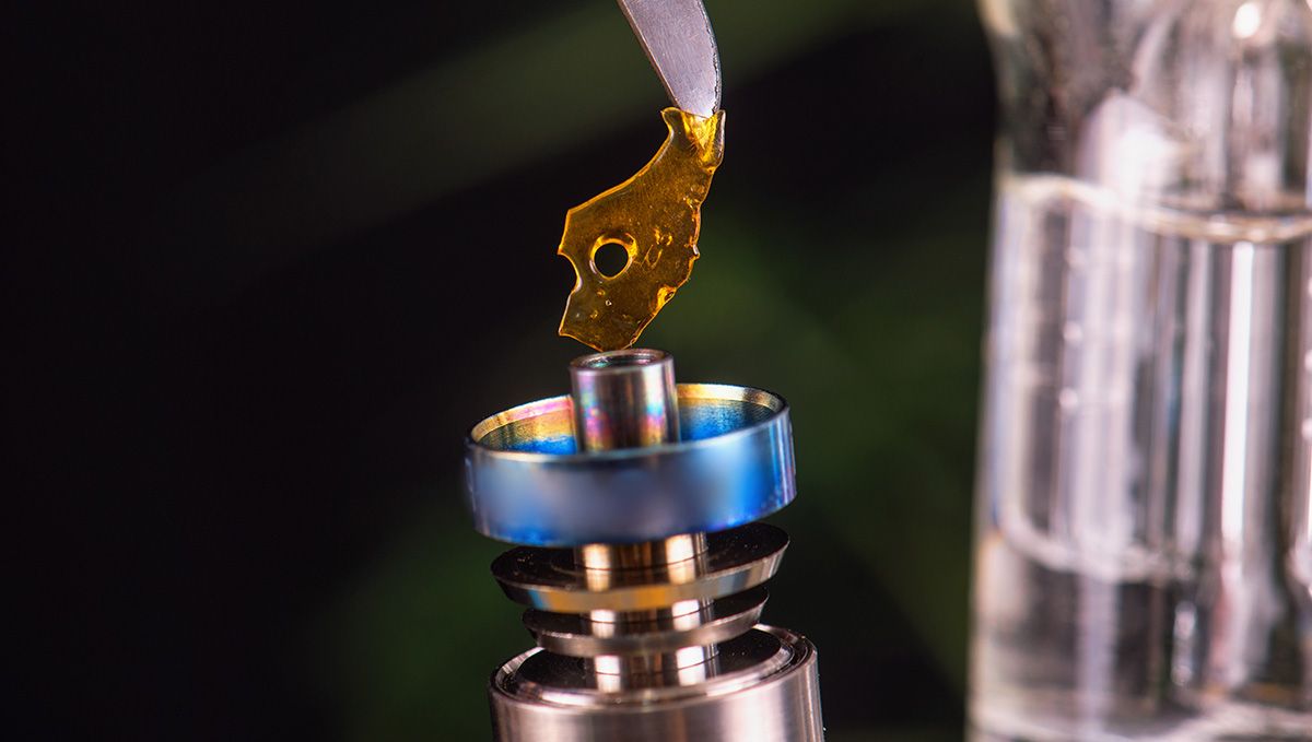 Cannabis Shatter: What Is It, How To Make And Smoke THC & CBD Hash Oil: A piece of shatter being placed on the heating element of a dab rig Cannabis Shatter: What Is It, How To Make And Smoke THC & CBD Hash Oil: A piece of shatter being placed on the heating element of a dab rig