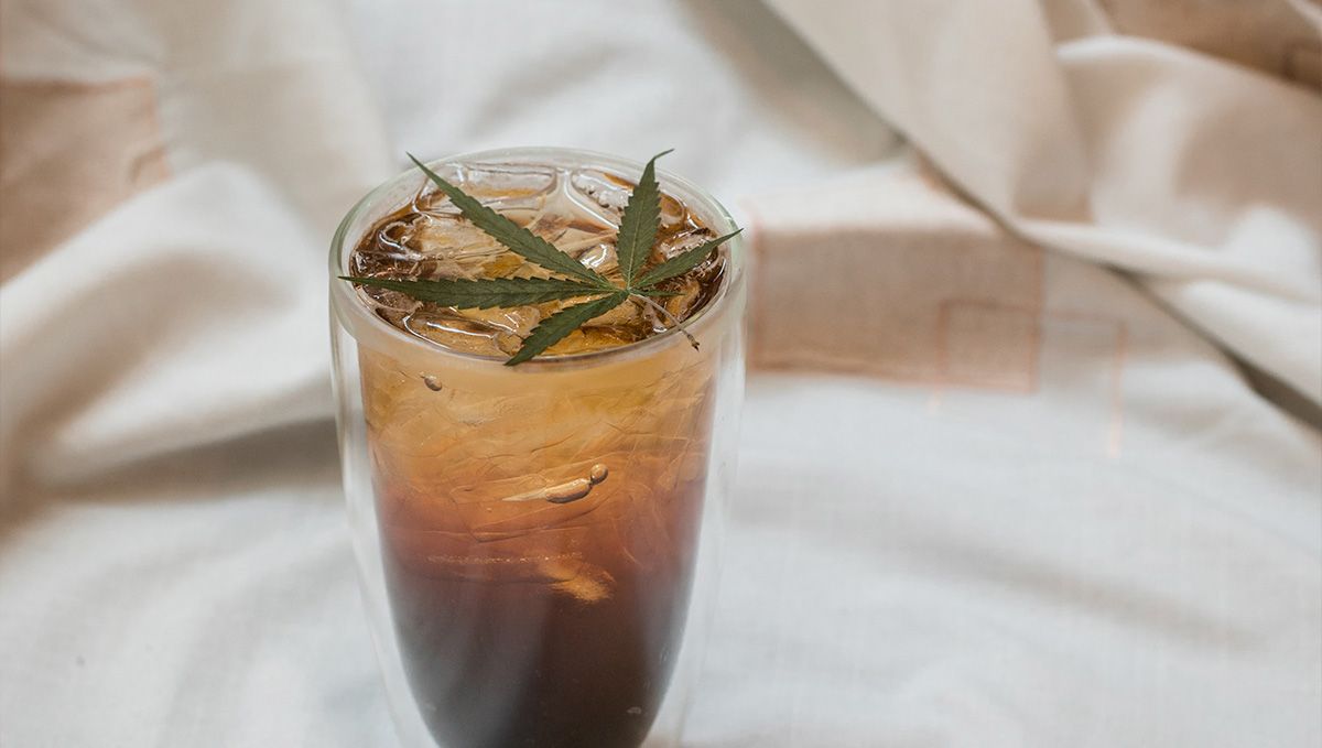 THC Syrup Explained: What Is THC Lean & How to Make It: A brownish soft drink with ice in a tall transparent glass with a fresh marijuana leaf on top THC Syrup Explained: What Is THC Lean & How to Make It: A brownish soft drink with ice in a tall transparent glass with a fresh marijuana leaf on top